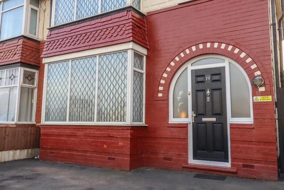 Red-brick exterior of 19 Slinger Road with leaded bay windows and arched doorway