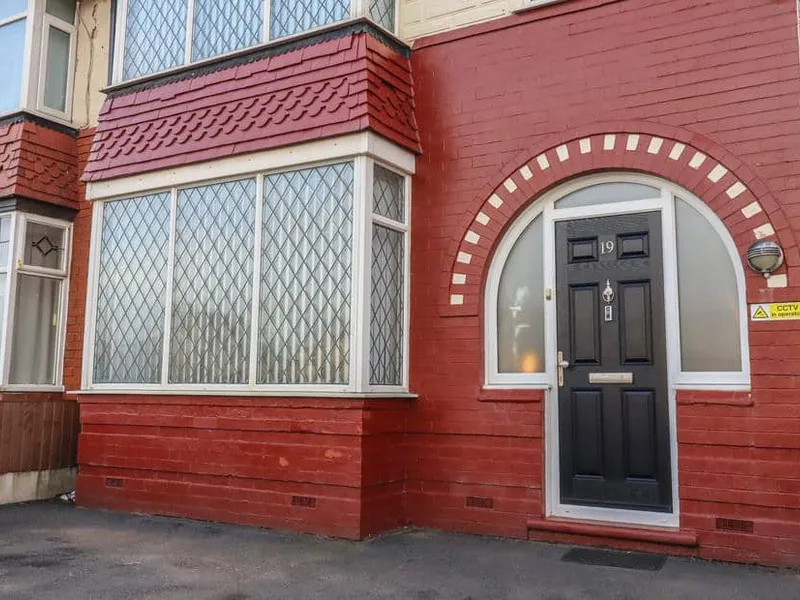 Red-brick exterior of 19 Slinger Road with leaded bay windows and arched doorway