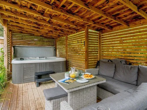 Covered patio with hot tub and outdoor seating area