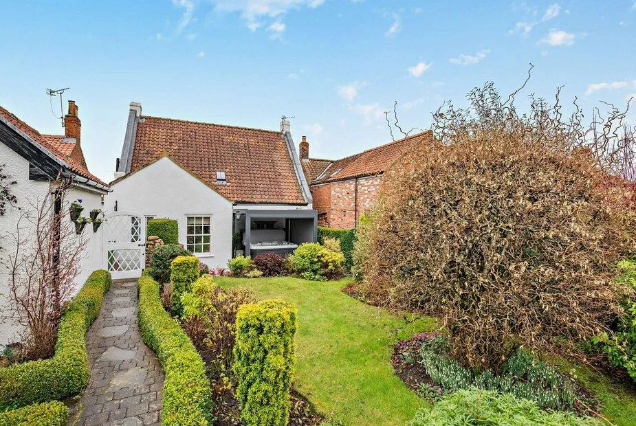3 Bed Cottage with red tile roof and landscaped front garden.