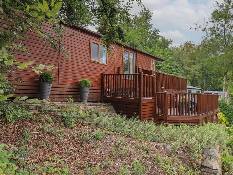 Acorn Bank Lodge with raised deck surrounded by trees and potted plants