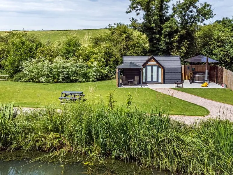 Acorn Lodge with outdoor hot tub, garden area and pond in a countryside setting