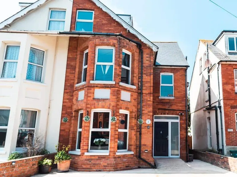 Anchor House red-brick exterior with bay window and potted plants at the entrance