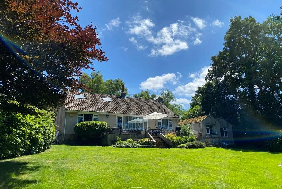 Birchcroft Hideaway with decked patio and outdoor dining area overlooking a large lawn