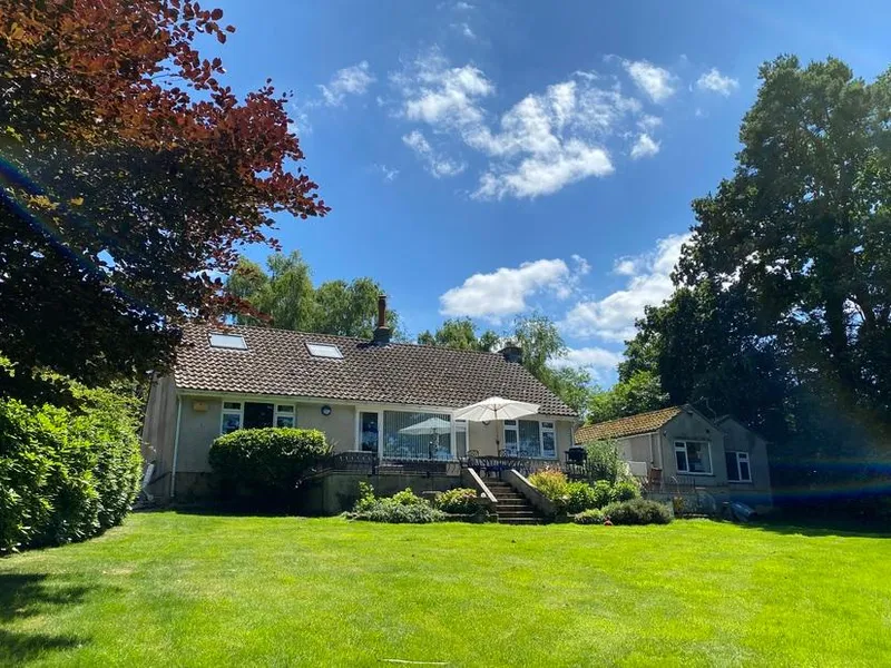 Birchcroft Hideaway with decked patio and outdoor dining area overlooking a large lawn