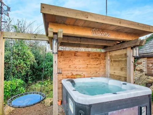 Cottage garden with covered hot tub and round swing