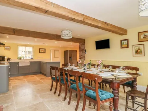 Kitchen and dining area with wooden table set for eight