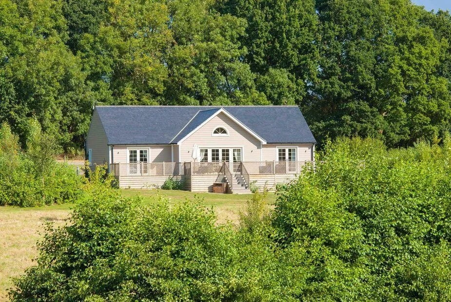 Endymion Lodge with large decking surrounded by trees and greenery