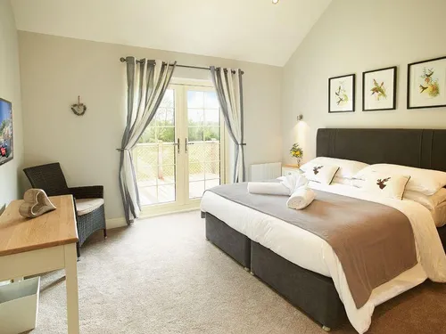 Lodge bedroom with double bed and French doors to balcony