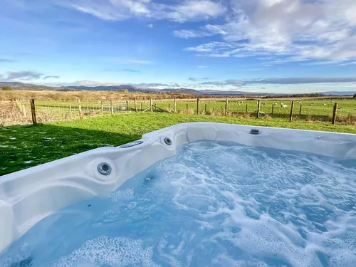 Cottage garden with hot tub and view of fields and hills