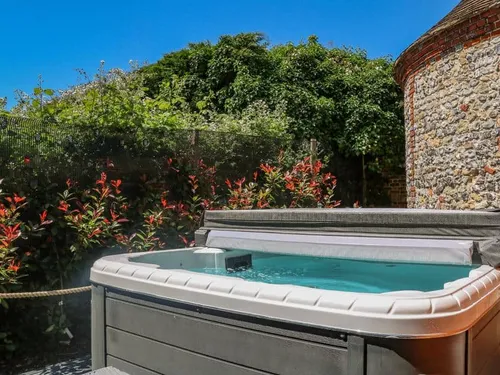 Hot tub beside stone wall and plants