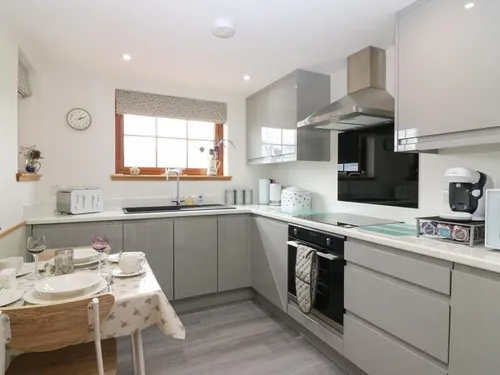 Kitchen with modern cabinets, oven and small dining table set for two