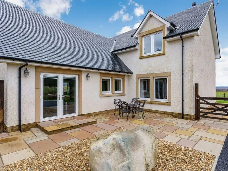 Gartclach exterior with stone patio, outdoor table and rural views