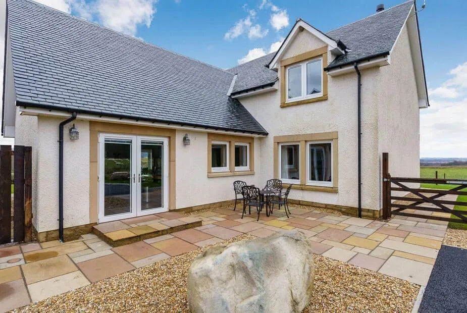 Gartclach exterior with stone patio, outdoor table and rural views