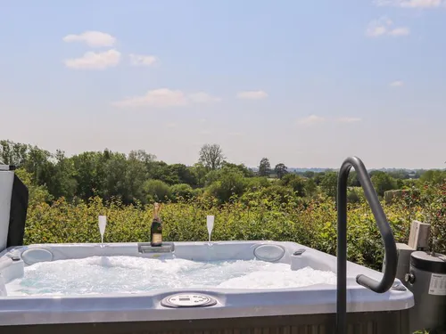 Cottage outdoor hot tub with countryside view and champagne bottle