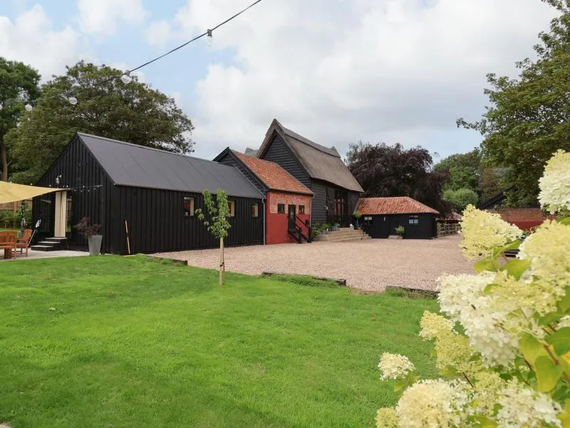 Halcyon Barn with outdoor seating area and gravel driveway in garden setting