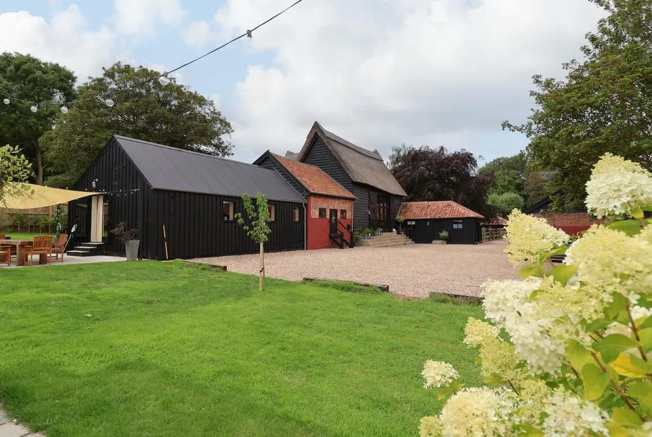 Halcyon Barn with outdoor seating area and gravel driveway in garden setting