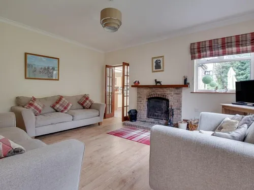Living room with fireplace, two sofas, and television by window