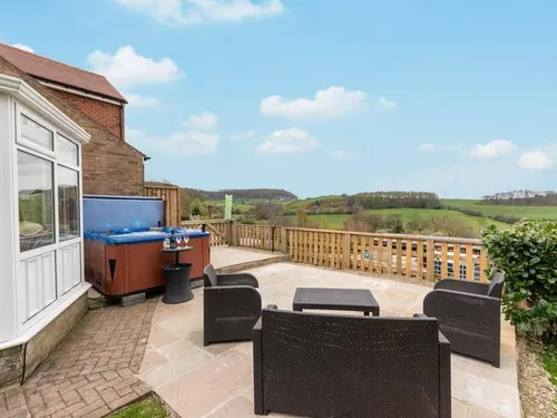 Cottage patio with seating area and hot tub overlooking countryside views