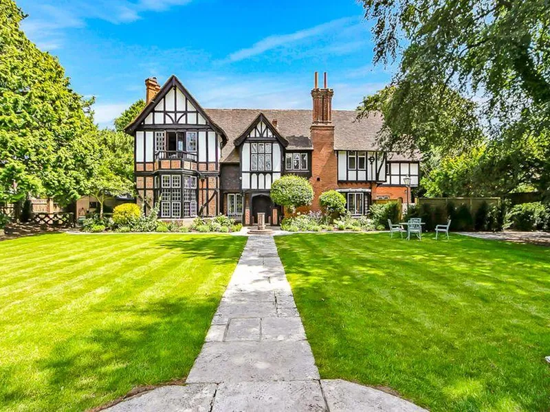 Highbury Mansion with extensive front lawn and stone path leading to entrance