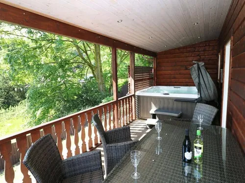 Lodge covered deck with rattan dining set and hot tub