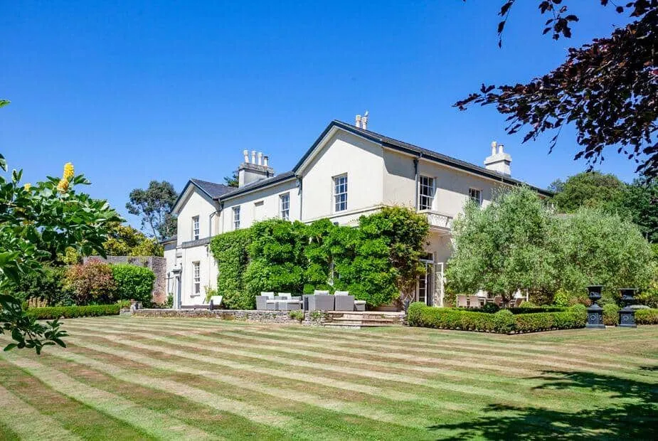 Laguna Mansion with outdoor seating overlooking a large striped lawn and gardens
