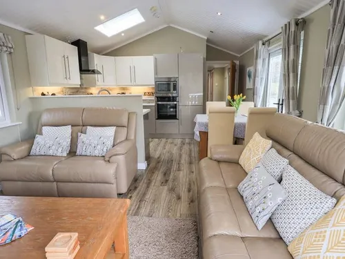 Lodge living area with two sofas, coffee table and open-plan kitchen in background