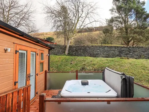 Lodge decking area with hot tub and hillside view