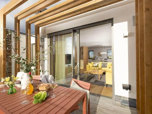 Lodge patio with outdoor dining table, view into living room through sliding glass doors