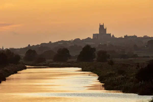 Golden sunset silhouette of Lincoln Cathedral sitting high on the hill overlooking the River Witham.