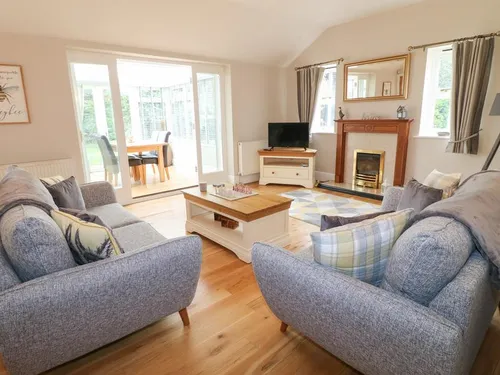 Living room with sofas, coffee table and fireplace, view to dining area