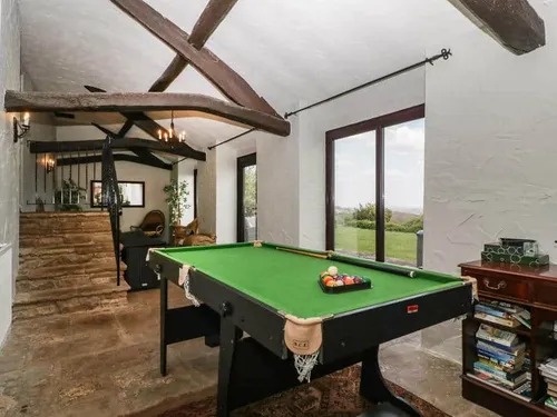 Cottage games room with pool table and sliding glass doors to the garden