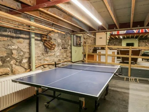 Cottage games room with table tennis table and dartboard
