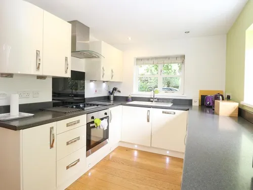 Lodge kitchen with white cabinets, electric hob and window above sink