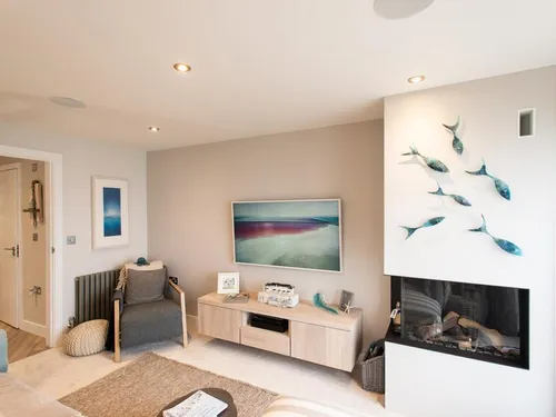 Cottage living room with wall-mounted fireplace and fish decorations