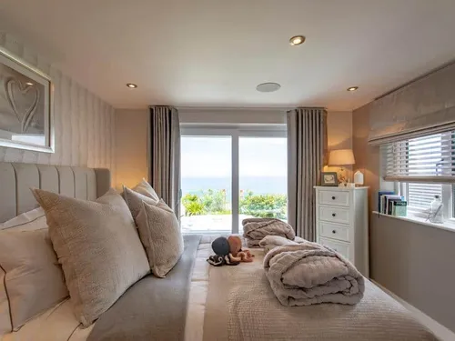 Cottage bedroom with double bed and sea view through large window
