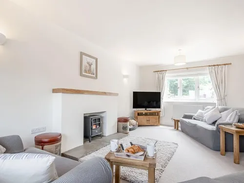 Cottage living room with wood burner, sofas and television