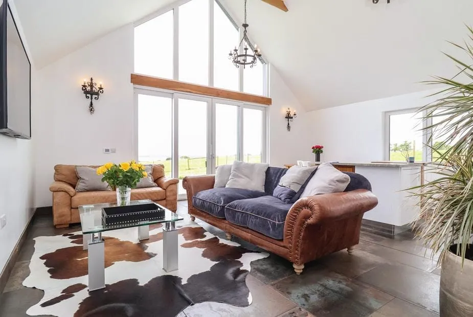 Polly's Annexe lounge with large windows, cowhide rug and countryside views