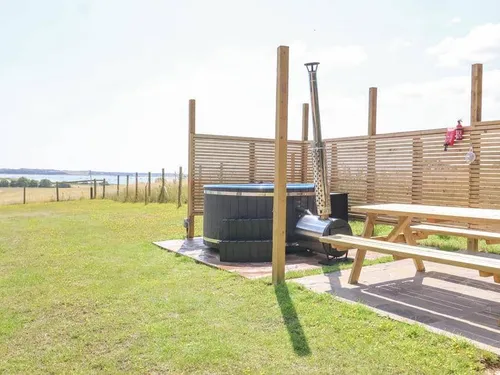 Cottage garden with wood-fired hot tub and picnic bench on grass