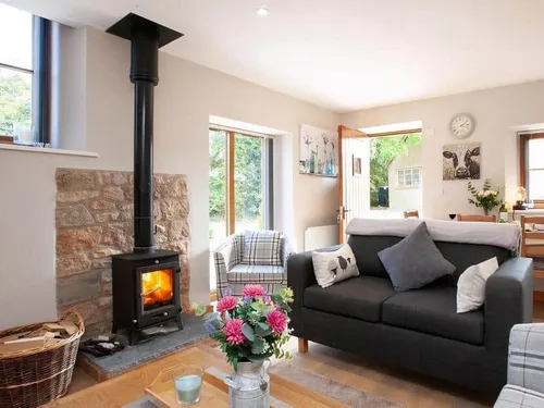 Cottage lounge with log burner and grey sofa