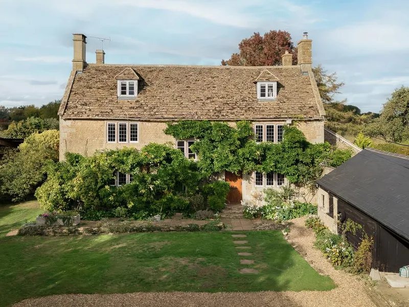Reybridge House with stone exterior and climbing greenery overlooking a lawn garden