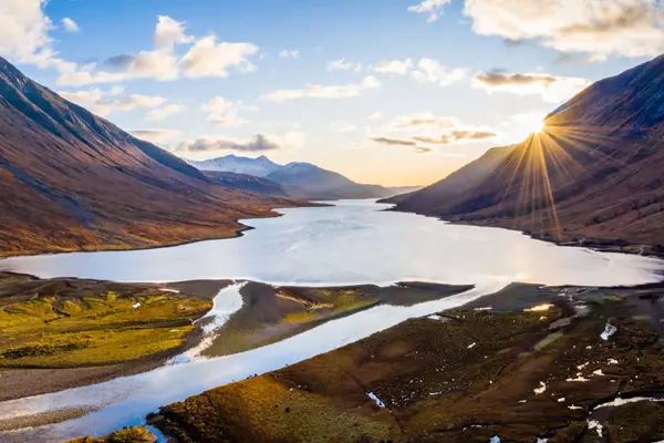 Sunset bursting over the mountains and waters of Loch Etive in the Scottish Highlands.