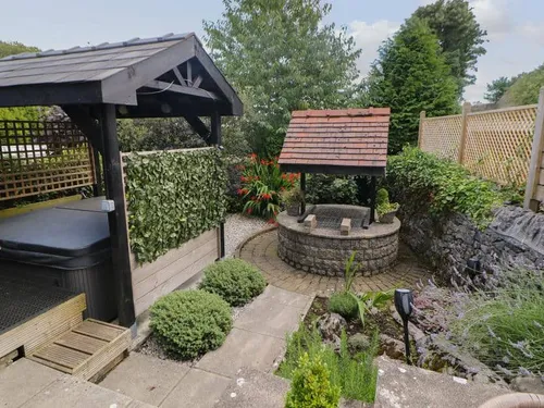 Cottage garden with covered hot tub and stone wishing well