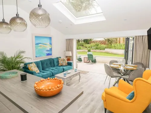 Cottage living area with skylight, open patio doors, and lounge seating