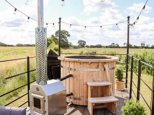 Lodge deck with wood-fired hot tub and countryside views