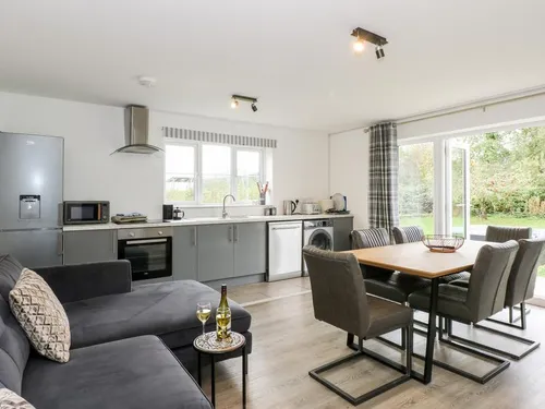 Kitchen and dining area with sofa and patio doors to garden