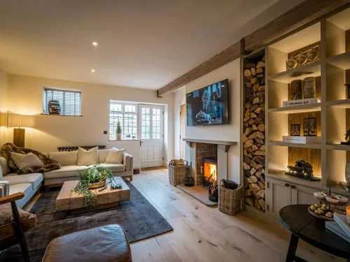 Living room with wood burner, built-in shelves and log storage