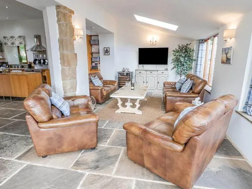 Cottage living room with leather sofas and wall-mounted TV