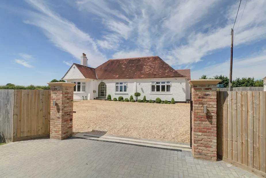 The Little Paddock with red tiled roof, gravel driveway and wooden gated entrance