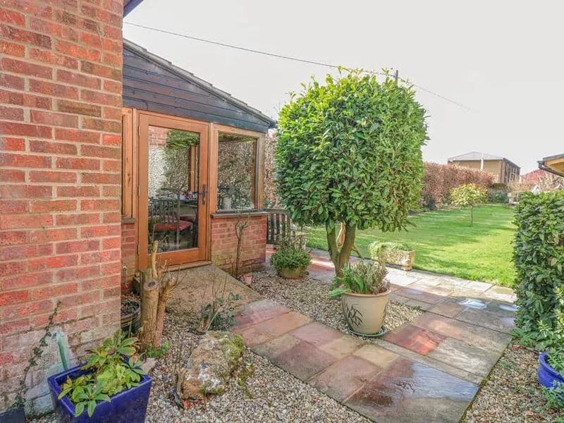 The Lodge patio with potted plants and lawn area visible through glass doors